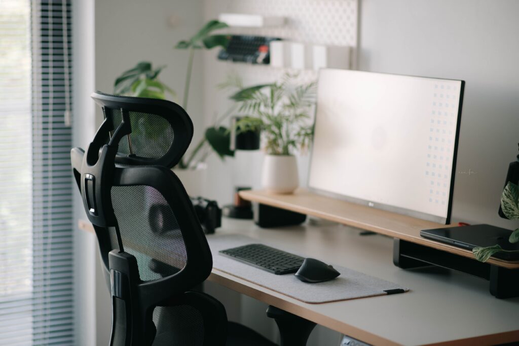 Ergonomicchair | gearandcode Ergonomic office chair at a clean desk with a large monitor keyboard mouse and green plants by a window